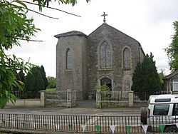 The Roman Catholic parish church. An inscribed stone high up on the gable reads "THIS TEMPLE was erected to the honour and glory of GOD By the Revd George Canavan P.P. in the year of our Lord 1836"