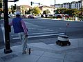 Man and delivery robot waiting at pedestrian crosing in Redwood City, California