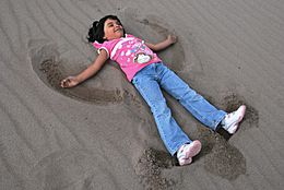Girl Making a Sand Angel (12660998534)