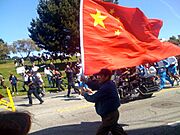 Guy with a large PRC flag running along side of torch 20080409