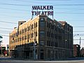 Flatiron-shaped brick building with "Walker Theatre" in large red letters