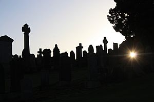 Silhouetted stones at sunset in Wellshill Cemetery, Perth