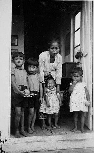 COLLECTIE TROPENMUSEUM Portret van een baboe met kinderen in de deuropening van een huis voor Europeanen op Aek na Oeli TMnr 60051111