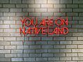 You Are On Native Land neon sign at Owamni by The Sioux Chef in Minneapolis, Minnesota