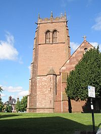A sandstone church with the embattled tower on the left, and the body of the church on the right, seen end-on