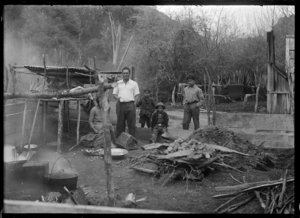 Group of men around a hangi at Te Whaiti, 1930. ATLIB 298389