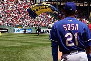 Major League Baseball's Sammy Sosa watches as a member of the Navy Parachute Team Leap Frogs lands in Boston's Fenway Park prior to a Red Sox Game