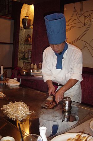Teppanyaki chef cooking at a hibachi in a Japanese Steakhouse