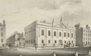 Neoclassical facade of the Royal College of Surgeons in Ireland with people walking