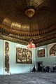 Salle de Sousse avec plafond doré et mosaïques sur les murs ainsi que sur le sol.