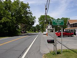 Sign along New York State Route 9L indicating Oneida Corners.