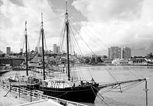 A sailing ship at a pier, starboard bow quarter view