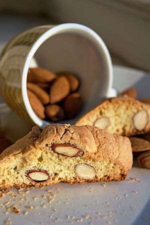 Two biscotti served with a cup of fresh almonds