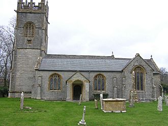 Gray stone building with square tower and slate roof.