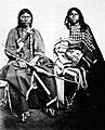 Photograph of a Kiowa couple showing elk teeth on the woman's dress 