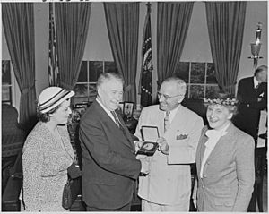Photograph of President Truman in the Oval Office, shaking hands with Vice President Alben Barkley as he presents him... - NARA - 200220