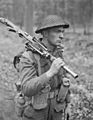 Private of the Canadian Perth Regiment advancing through forest north of Arnhem with Bren gun 1945