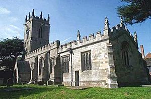 A stone church seen from the southeast, entirely battlemented, with pinnacles on the chancel and the tower