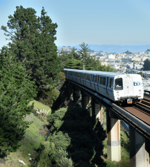 A southbound BART train passes San Francisco's Outer Mission neighborhood, between the Balboa Park station and the Daly City station. The photograph was taken on the pedestrian bridge next to the San Jose/Farallones stop of the SFMTA M line.