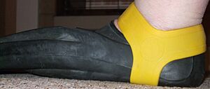 Yellow fin grip retaining a Technisub Ala swimming fin on the foot