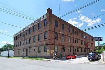 A three-story brick building seen from its right, so that two sides are visible in full. Below the flat roof in front the words "Port Business Center" are painted across.