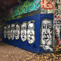 Graffiti - mens' faces on blue background - Parkland Walk, London