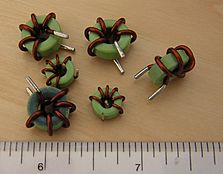 Several small toroidal inductors. The major scale is in inches.