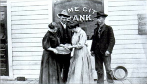 Two women, one of them Belinda Mulrooney, and two men stand in front of the Dome City Bank, which she founded