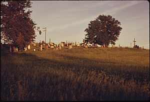ST. PATRICK'S CATHOLIC CEMETERY OUTSIDE OF ATCHISON, KANSAS, IN LATE AFTERNOON SUN. THE NATIVE STONE PIONEER CHURCH... - NARA - 557089