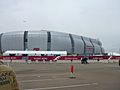 photo of the University of Phoenix Stadium taken from the parking lot, showing the domed stadium against an overcast sky