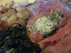 New York Strip with Beurre Maitre d'Hotel, potatoes and creamed spinach