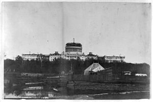 West front of the United States Capitol, with the new cast-iron dome under construction. In the foregrd. is the Tiber Creek or Washington City Canal and the octagonal greenhouse for the LCCN2002709520