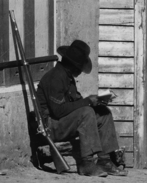 African-American Corporal (United States Colored Troops) reading at 8 Whitehall Street, Atlanta slave auction house, Fall 1864, from- 'Auction & Negro Sales,' Whitehall Street LOC cwpb.03351 (cropped)