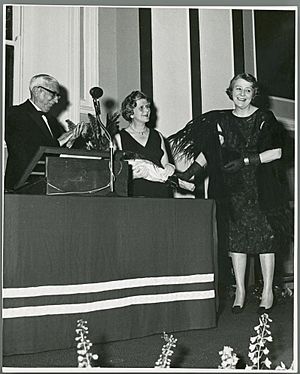 Photograph of reception and presentation on Michael Tierney's retirement as President of UCD : Presentation of a bouquet of flowers to Eibhlín Tierney (centre) by Carmel Humphries (on the right).