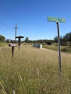 Road signs in Lochiel. Part of the town and the international border can be seen in the background.