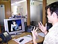 Deaf or HoH person at his workplace using a Video Relay Service to communicate with a hearing person via a Video Interpreter and sign language SVCC 2007 Brigitte SLI + Mark