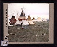 -Woman chopping firewood, Eagle tipi in foreground, Star tipi on left-. 815