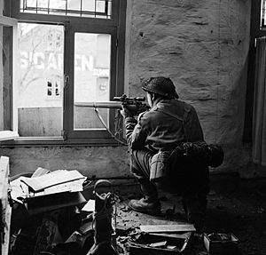 A sniper from "C" Company, 5th Battalion, The Black Watch in position in a ruined building in Gennep, Holland, 14 February 1945. B14626
