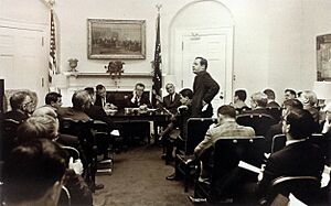 Dr. William Conrad Gibbons (standing), Lyndon Johnson seated in the background