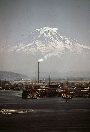 MT. RAINIER, WITH PORT OF TACOMA IN FOREGROUND. STACK BELCHING SMOKE MARKS THE KAISER ALUMINUM PLANT - NARA - 545243