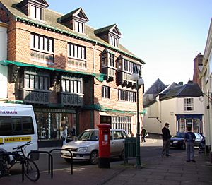 Street scene with buildings and shops. The three storey building on the left has a sign saying The Courthouse.