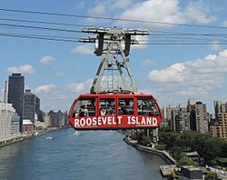 A red-colored tram going over a river
