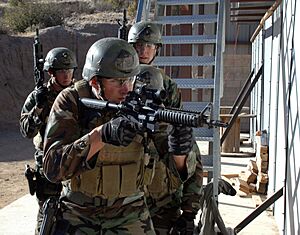 US Navy 071019-N-6552M-024 A team of four SEAL trainees prepare to breach a room during a SEAL qualification training exercise