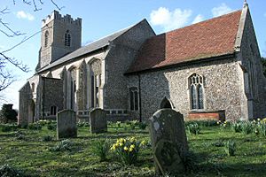 A stone church seen from the southeast, showing a chancel with a red tiled roof, a much larger nave with a slated roof, and a battlemented tower