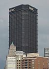  a black tower with a triangular floor plan. You can see two of the sides with the acronym "UPMC" sits at the top of each side.