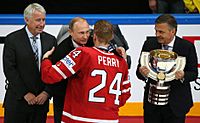 photograph of a man in a red sweater giving a hug for a man wearing a suit