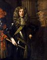 Formal three quarter length portrait of James aged about thirty. He has a long face with large cleft chin and red lips. He has long blonde hair and poses in black armour, with a brocade sash and lace cravate and clasped a baton in his right-hand.