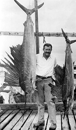 Portrait of author Ernest Hemingway posing with sailfish Key West, Florida