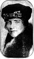 A portrait photograph of a young woman in a cloche hat and fur coat