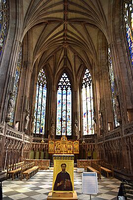 Interior view of a harmonious Gothic interior with tall windows which have tracery in a reticular (or net) pattern. 